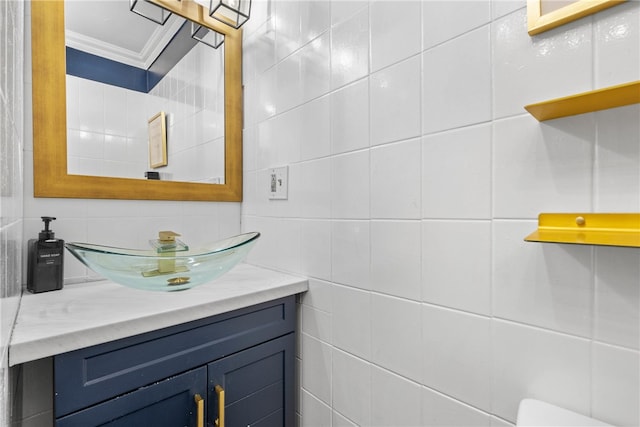 bathroom featuring tile walls, vanity, and crown molding