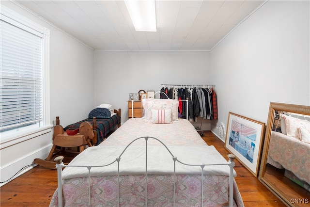 bedroom with ornamental molding and wood-type flooring