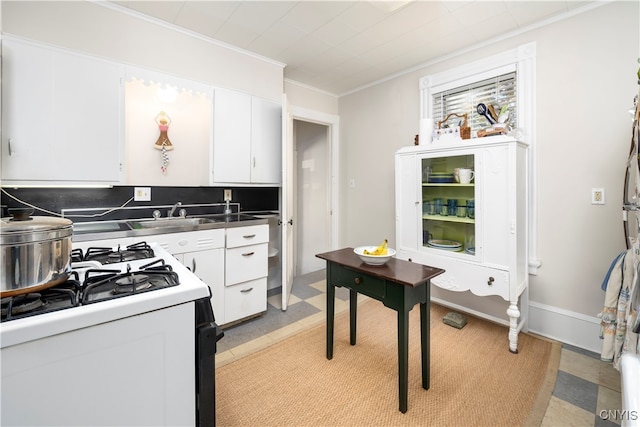 kitchen featuring white cabinetry, white range, stainless steel counters, and crown molding