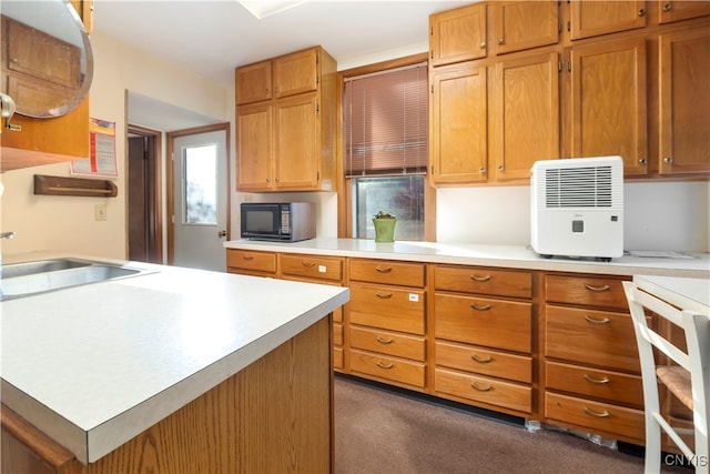 kitchen with dark colored carpet, sink, and a center island