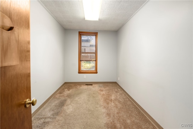 carpeted empty room with a textured ceiling and crown molding