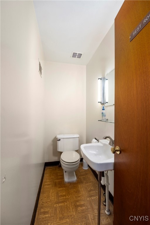 bathroom with parquet flooring and toilet