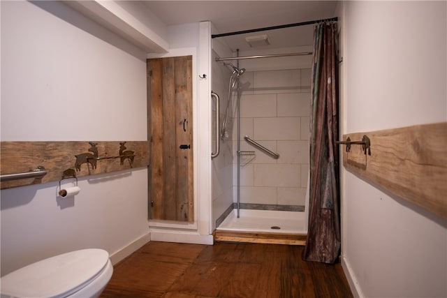 bathroom with a shower with curtain, hardwood / wood-style flooring, and toilet