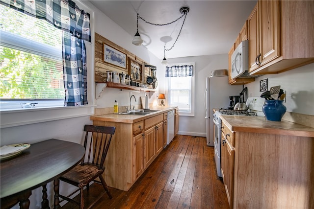 kitchen with dark wood-type flooring, white appliances, sink, and pendant lighting