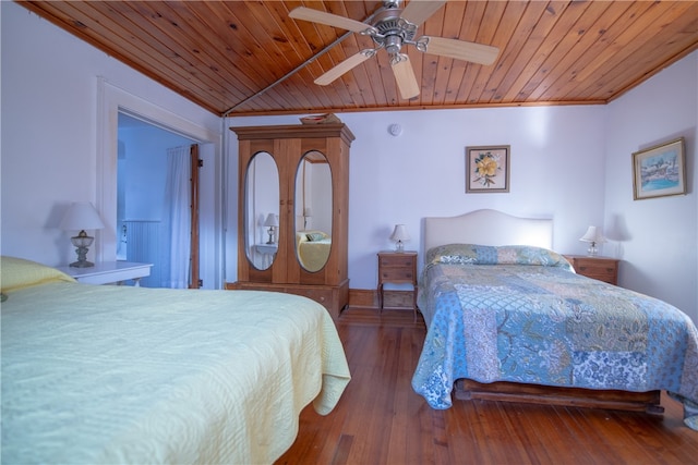 bedroom with dark wood-type flooring, ceiling fan, wood ceiling, and ornamental molding