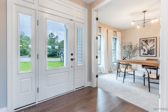 entryway featuring an inviting chandelier and dark hardwood / wood-style floors