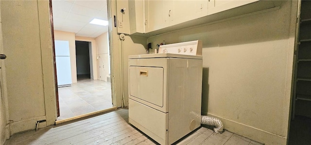 laundry area with cabinets, washer / clothes dryer, and light hardwood / wood-style flooring