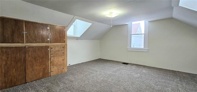 bonus room with dark carpet and lofted ceiling