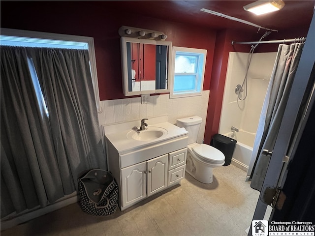 full bathroom featuring toilet, shower / tub combo with curtain, and vanity