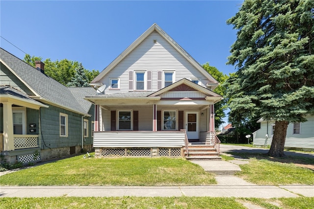 bungalow featuring covered porch and a front yard