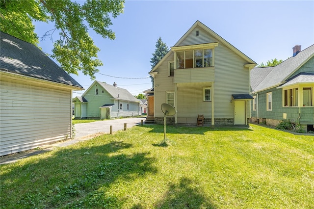 rear view of property featuring a lawn