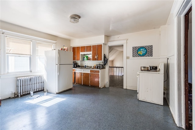 kitchen with radiator, sink, and white refrigerator