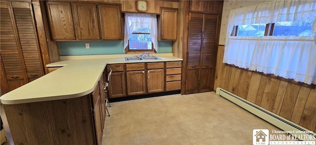 135 N 12th St, Olean, NY 14760 - kitchen with baseboard heating, light countertops, brown cabinetry, a peninsula, and light floors