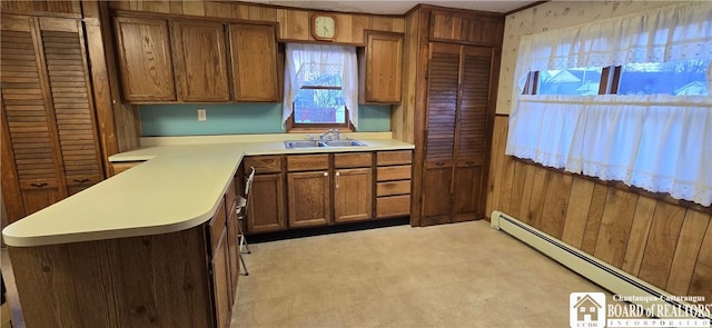 135 N 12th St, Olean, NY 14760 - kitchen with baseboard heating, light countertops, brown cabinets, light floors, and a peninsula