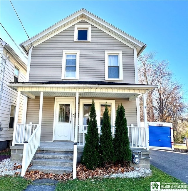 view of front of house featuring an outbuilding, a garage, and covered porch