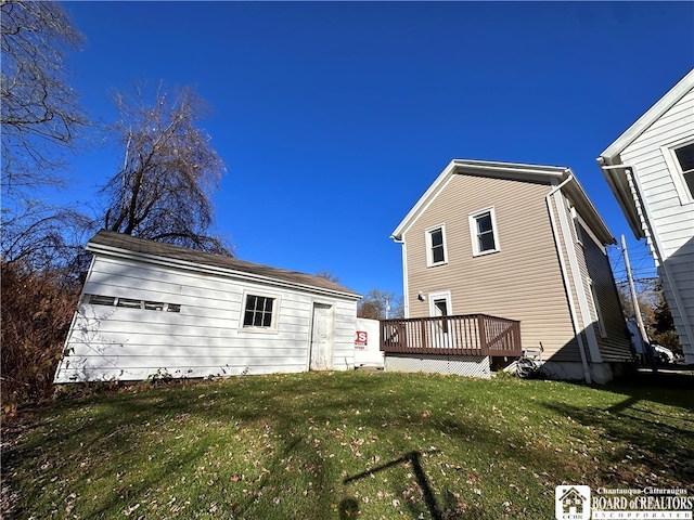 rear view of property featuring a deck and a lawn