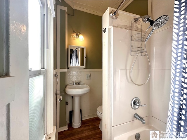 bathroom with tile walls, toilet, hardwood / wood-style flooring, and shower / bath combo with shower curtain