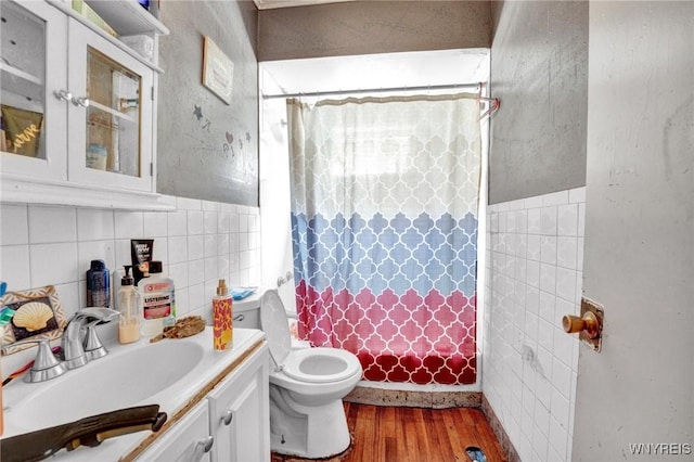 bathroom with vanity, a shower with shower curtain, toilet, tile walls, and wood-type flooring