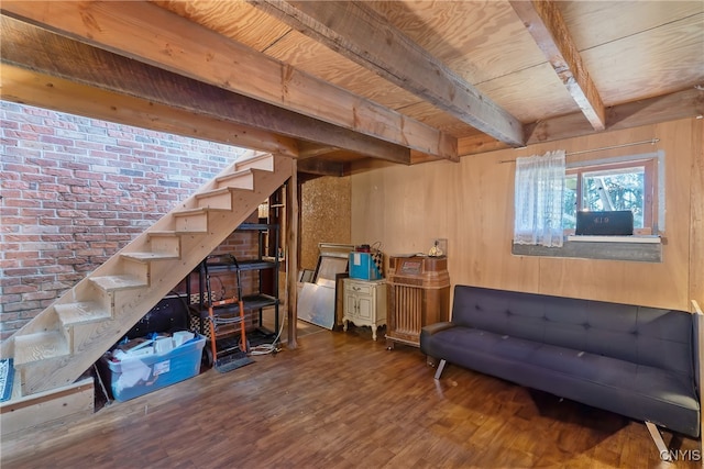 basement with hardwood / wood-style flooring and brick wall