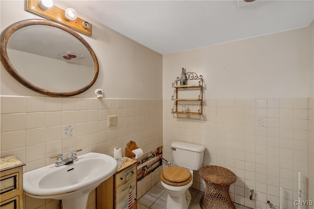 bathroom with tile walls, sink, and toilet