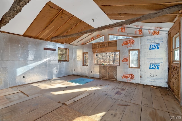 unfurnished room featuring vaulted ceiling and plenty of natural light