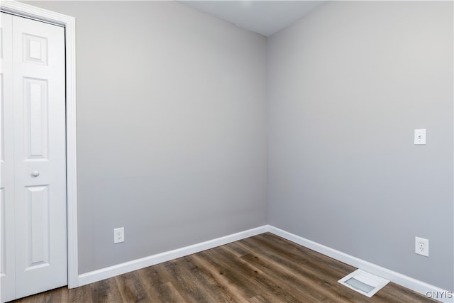 unfurnished room with dark hardwood / wood-style flooring