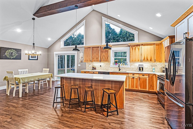 kitchen featuring a center island, hardwood / wood-style floors, high vaulted ceiling, backsplash, and appliances with stainless steel finishes