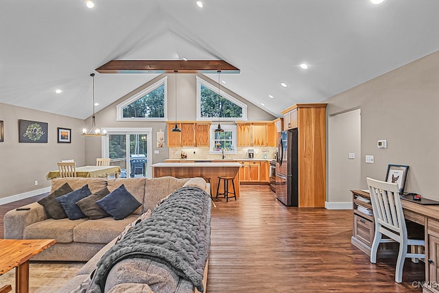 living room with dark wood-type flooring, beamed ceiling, plenty of natural light, and an inviting chandelier