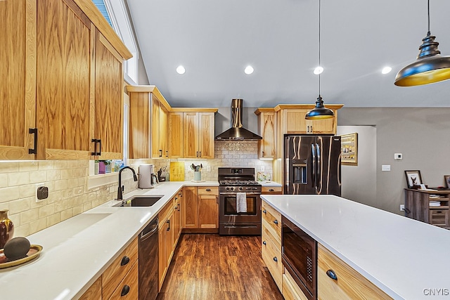 kitchen featuring fridge with ice dispenser, pendant lighting, sink, wall chimney exhaust hood, and gas range