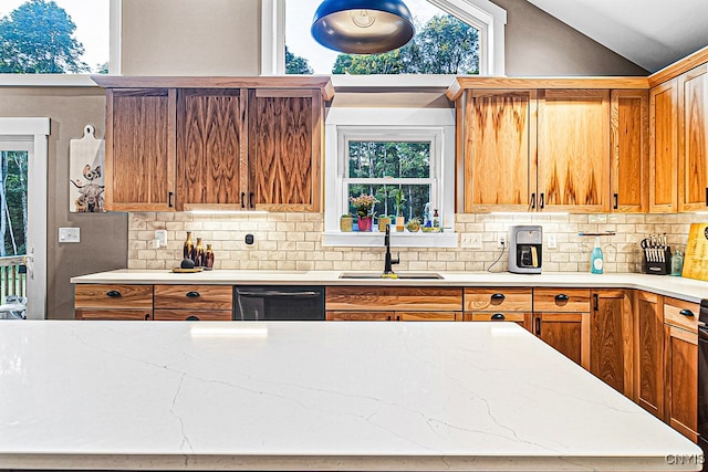 kitchen featuring dishwasher, lofted ceiling, sink, and tasteful backsplash