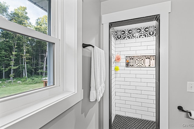 bathroom with tiled shower and plenty of natural light