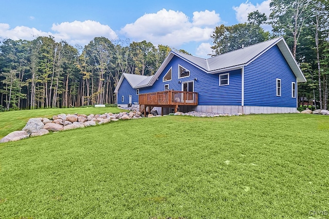 rear view of property featuring a wooden deck and a yard