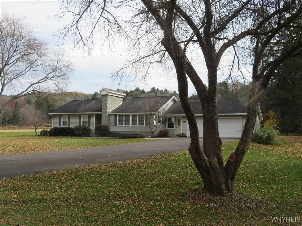 ranch-style home with a front lawn and a garage