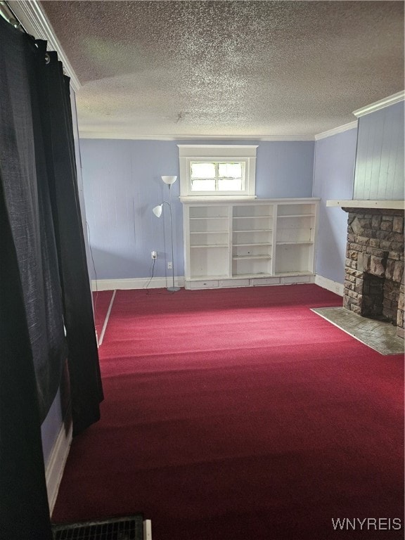 interior space featuring a stone fireplace, carpet, a textured ceiling, and ornamental molding