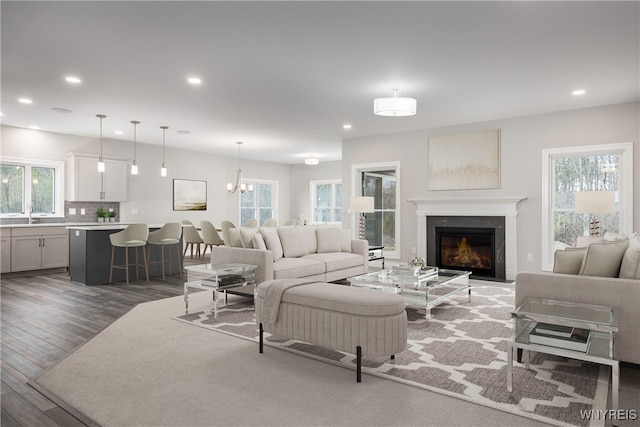 living room featuring dark hardwood / wood-style flooring, sink, and an inviting chandelier