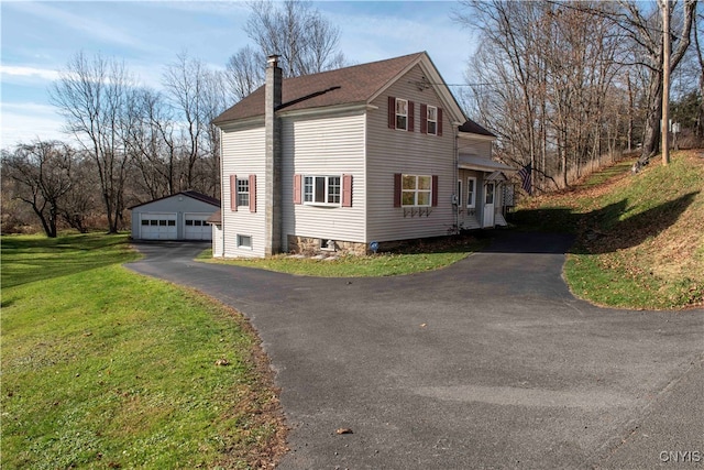 view of side of property featuring a garage, an outdoor structure, and a yard