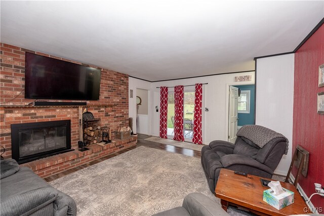 living room with wood-type flooring and a brick fireplace