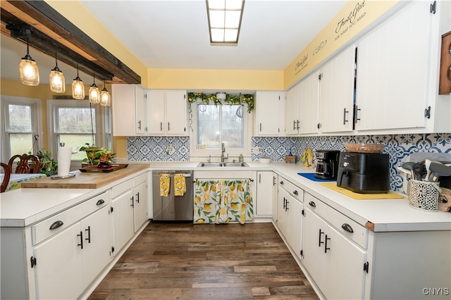 kitchen featuring sink, dark wood-type flooring, stainless steel dishwasher, pendant lighting, and white cabinets