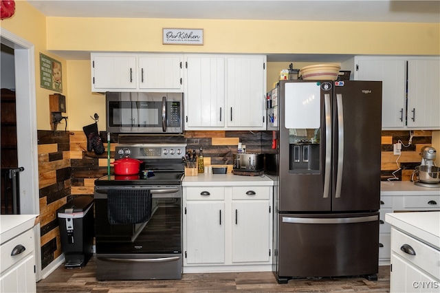 kitchen featuring tasteful backsplash, white cabinetry, stainless steel appliances, and dark hardwood / wood-style floors