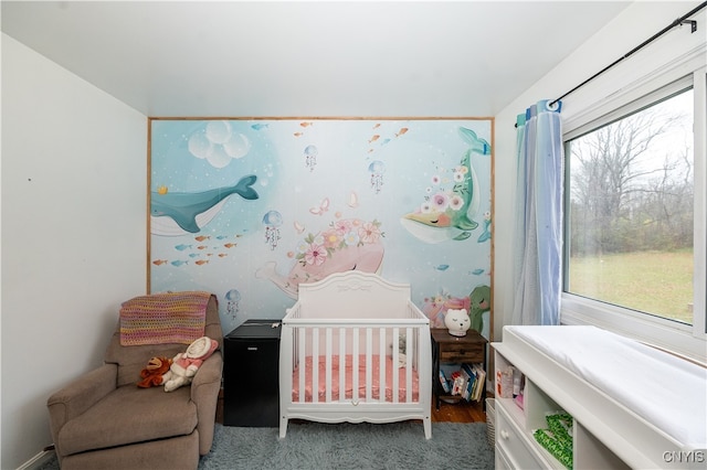 bedroom with multiple windows, hardwood / wood-style flooring, and a nursery area