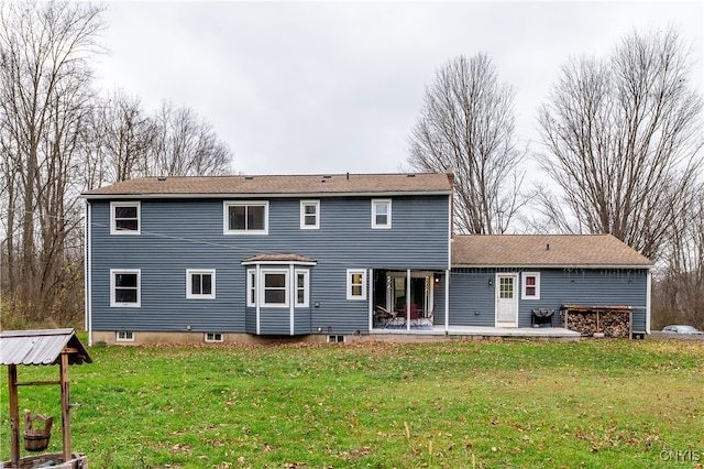 back of house with a yard and a patio