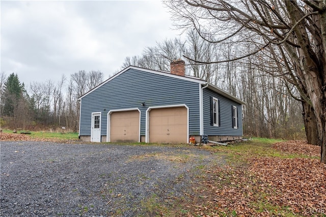 view of side of property with an outdoor structure and a garage