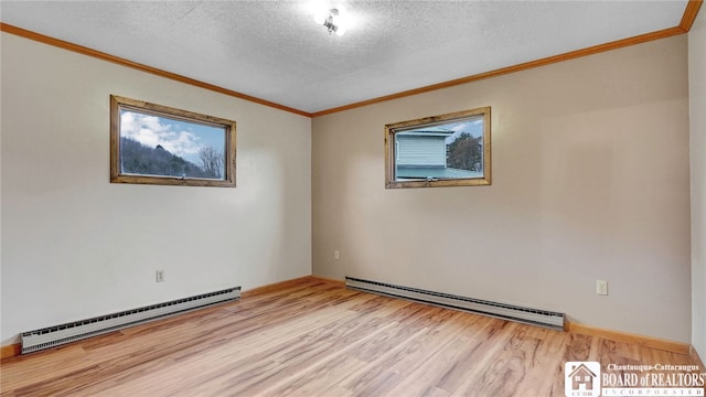 spare room featuring light hardwood / wood-style floors, a textured ceiling, a baseboard heating unit, and ornamental molding