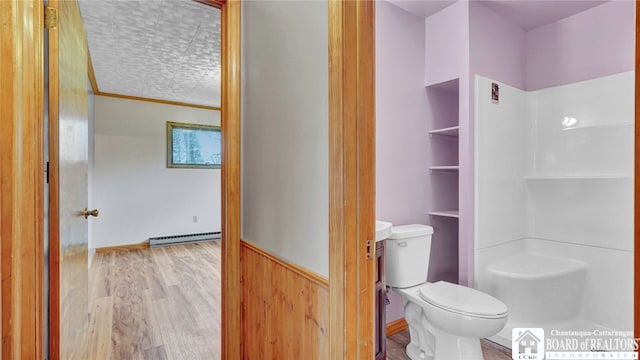 bathroom featuring walk in shower, toilet, hardwood / wood-style flooring, and a baseboard heating unit