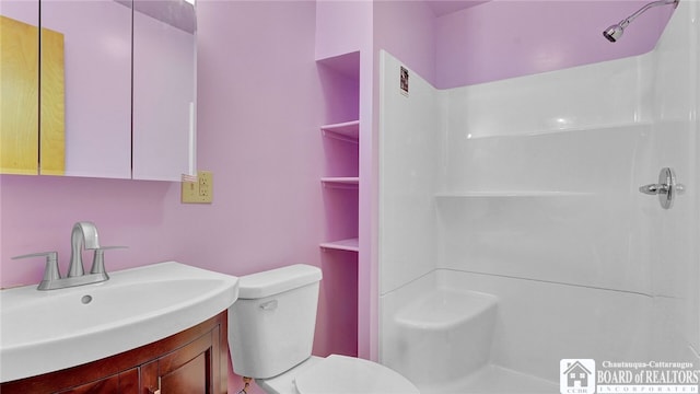 bathroom featuring walk in shower, vanity, and toilet