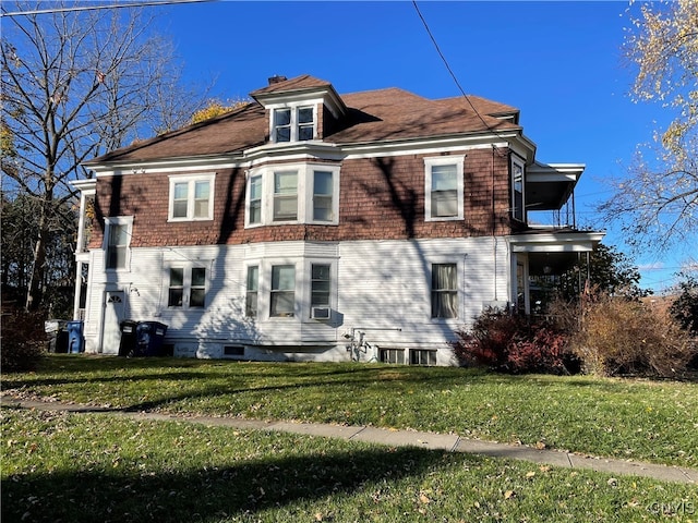 rear view of property featuring a lawn and cooling unit