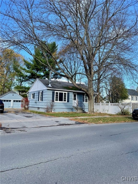 view of front of property featuring a garage and an outbuilding