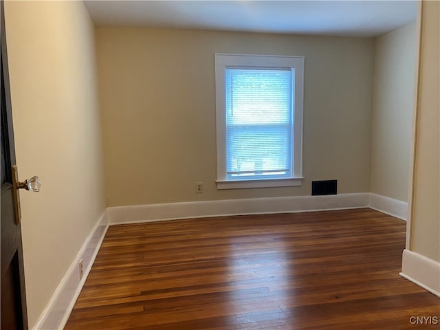 spare room with dark wood-type flooring