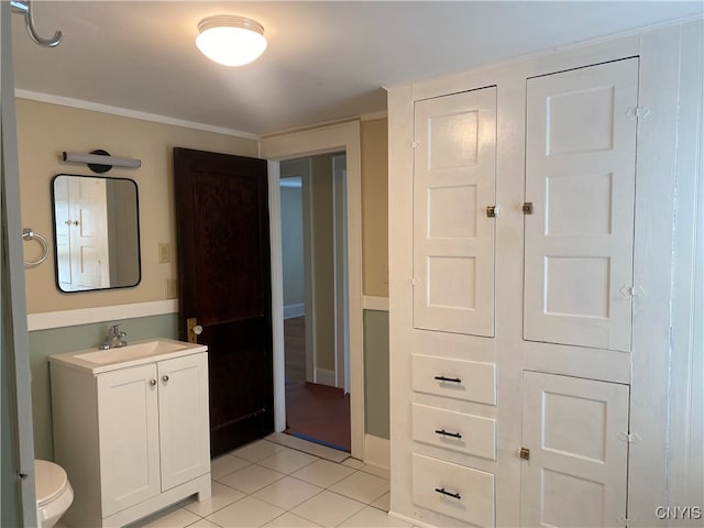 bathroom with toilet, vanity, tile patterned floors, and ornamental molding