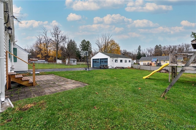 view of yard featuring a playground, an outbuilding, and a patio